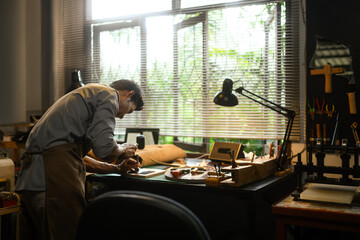 Dedicated craftsman engrossed in his work at a workshop. Small business and Handmade concept