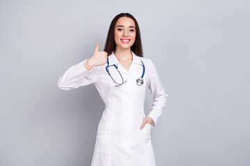 Photo of professional medical worker lady thumb up empty space white coat isolated on grey color background