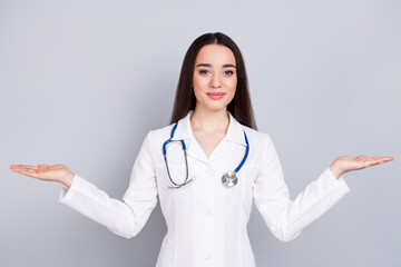 Photo of professional medical worker lady hold empty space vs white coat isolated on grey color background