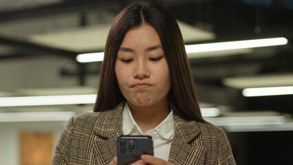 Sad frustrated frown failure stressed upset Asian woman business worker user Japanese student girl looking mobile phone bad news problem lost smartphone Korean businesswoman Chinese female in office