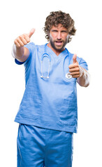 Handsome hispanic surgeon doctor man over isolated background approving doing positive gesture with hand, thumbs up smiling and happy for success. Looking at the camera, winner gesture.