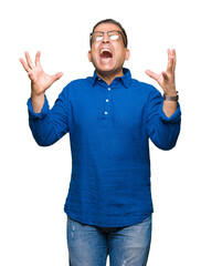 Middle age arab man wearing glasses over isolated background celebrating mad and crazy for success with arms raised and closed eyes screaming excited. Winner concept