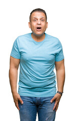 Middle age arab man wearing blue t-shirt over isolated background afraid and shocked with surprise expression, fear and excited face.