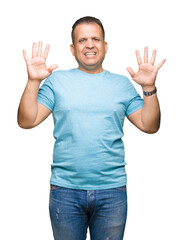 Middle age arab man wearing blue t-shirt over isolated background showing and pointing up with fingers number ten while smiling confident and happy.