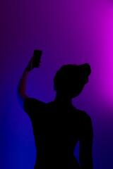 Dark profile of sexy girl on colored background.