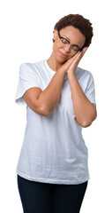 Beautiful young african american woman wearing glasses over isolated background sleeping tired dreaming and posing with hands together while smiling with closed eyes.