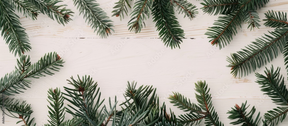 Aufkleber Minimal Christmas composition featuring a frame constructed from fir tree branches arranged on a white wooden surface This image embodies the essence of Christmas winter and the new year with a flat