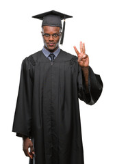 Young graduated african american man over isolated background showing and pointing up with fingers number three while smiling confident and happy.