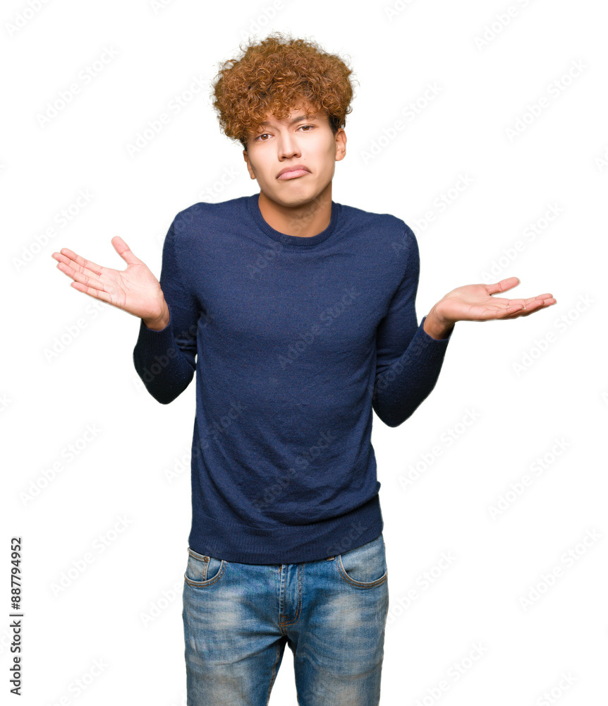 Wall mural Young handsome man with afro hair clueless and confused expression with arms and hands raised. Doubt concept.