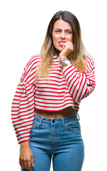 Young beautiful woman casual stripes winter sweater over isolated background looking stressed and nervous with hands on mouth biting nails. Anxiety problem.