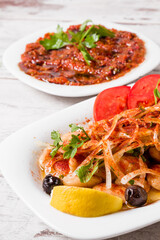 Refreshing traditional Turkish recipe onion salad with lemon slices and herbs served on a white plate offering a vibrant and healthy dish for meals.