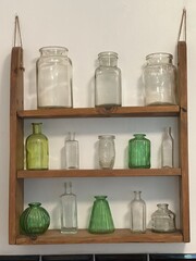 Rustic wooden shelves with glass jars and bottles
