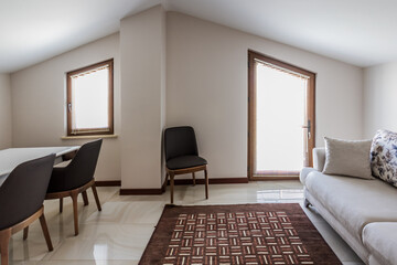 Modern living room interior with stylish furniture and a large window providing a bright and comfortable space for relaxation.