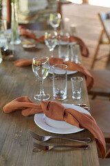 Wedding decoration. Floristics. Setting the table with brown napkins tied in a knot.