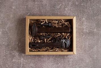Close-up of chocolate tools in cardboard box on gray background