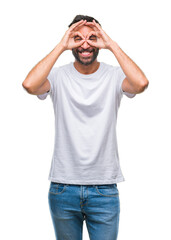 Fototapeta premium Adult hispanic man over isolated background doing ok gesture like binoculars sticking tongue out, eyes looking through fingers. Crazy expression.