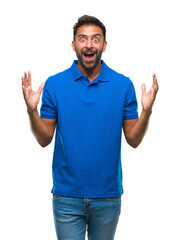 Fototapeta premium Adult hispanic man over isolated background celebrating crazy and amazed for success with arms raised and open eyes screaming excited. Winner concept