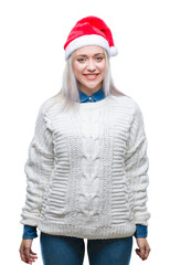 Young blonde woman wearing christmas hat over isolated background with a happy and cool smile on face. Lucky person.