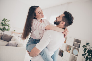 Fototapeta premium Photo of cheerful cute young couple enjoy weekend couple husband hold wife embrace buy new apartment indoors inside house home