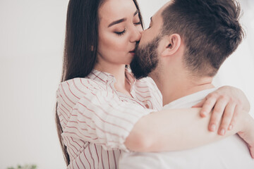 Photo of cheerful cute young couple enjoy weekend couple kissing hugging buy new apartment indoors inside house home