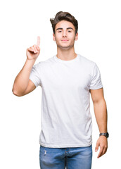 Young handsome man wearing white t-shirt over isolated background showing and pointing up with finger number one while smiling confident and happy.