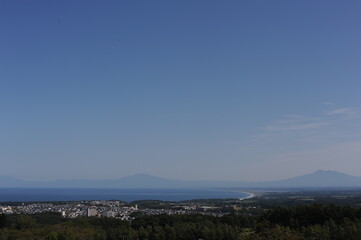 Panorama of Abashiri city with Mount Rausu and Mount Iō in the background on a sunny day with blue sky in summer, Hokkaido island, Japan
