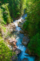 Obraz premium A stormy stream of water in a mountain river, view from above. Beautiful summer landscape.