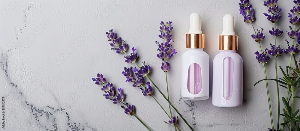 Fototapete top down view of two unbranded cosmetic serum bottles alongside a lavender bunch on a gray backdrop 