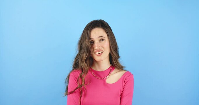 You suck, loser gesture. Dissatisfied and disappointed, skeptical adult female, shows thumb finger down, girl does not like something, gossips about people are bad disgusting isolated blue background.