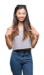 Young asian woman wearing sunglasses over isolated background looking confident with smile on face, pointing oneself with fingers proud and happy.