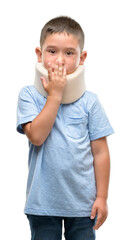 Dark haired little child injured wearing neck collar cover mouth with hand shocked with shame for mistake, expression of fear, scared in silence, secret concept