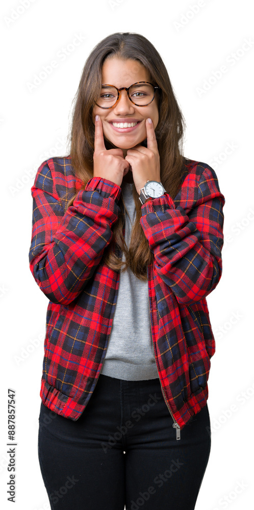 Sticker Young beautiful brunette woman wearing jacket and glasses over isolated background Smiling with open mouth, fingers pointing and forcing cheerful smile