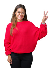 Young beautiful brunette woman wearing red winter sweater over isolated background smiling with happy face winking at the camera doing victory sign. Number two.