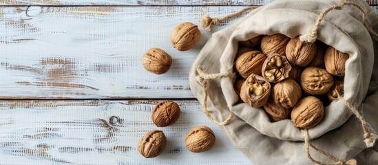 Walnuts arranged on a white wooden surface closed nuts in a cotton bag peeled kernels on a table highlighting natural raw food concept copy space image