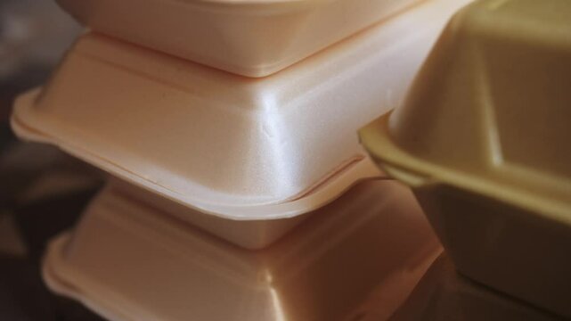 Takeaway boxes, foam boxes, rectangular shaped clamshell style container with an attached lid. Concept: single use containers.