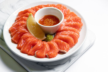 Fresh salmon sashimi serve on plate with spicy sauce. Japanese food style.