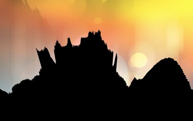 Golden yellow sunrise over the mountains in silhouette