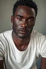 Obraz premium hyper realistic photograph of a handsome african american man in a t-shirt looking directly at the camera.
