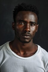 hyper realistic photograph of a handsome african american man in a white t-shirt looking directly at the camera.