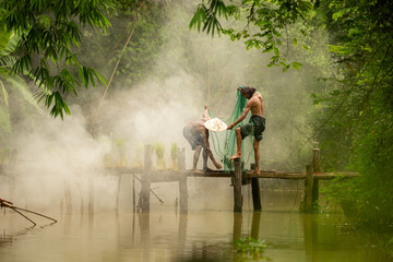 The farmer helps and talks to the fisherman who is using a fishnet to catch fish in the river