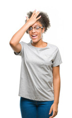Fototapeta premium Young afro american woman wearing glasses over isolated background surprised with hand on head for mistake, remember error. Forgot, bad memory concept.