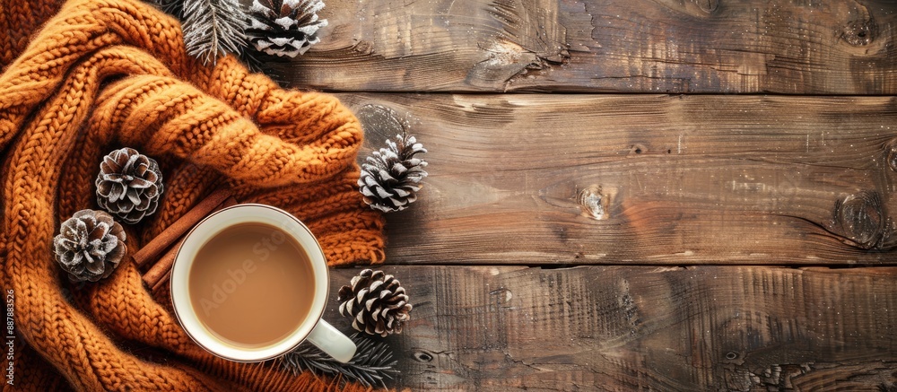 Poster Cozy autumn or winter scene with a cup of coffee soft blanket cinnamon pine cones on wooden backdrop Top view with ample copy space for an image