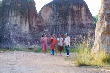 Elderly Asian women traveling and exploring a scenic rocky area. Dressed casually, holding water bottles, enjoying the sunny day, surrounded by nature, having a conversation, reflecting friendship