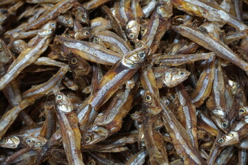 A pile of dried anchovies displayed in a fish market, Little dried fish in an Asian fish market, Fresh dried sardines and anchovies being displayed for selling at a seafood market