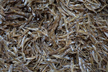 A pile of dried anchovies displayed in a fish market, Little dried fish in an Asian fish market, Fresh dried sardines and anchovies being displayed for selling at a seafood market