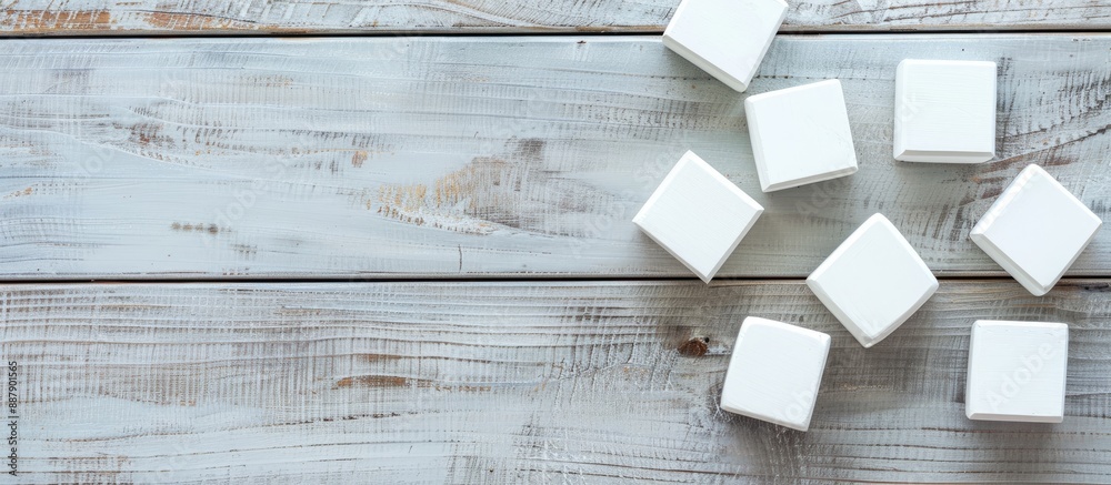 Poster Flat lay of blank cubes on a light grey wooden table with a free area for text Includes a copy space image