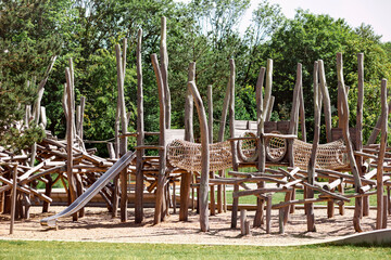 Playground Equipment on Nature. Modern Wood Playground with Slide , Rope Bridge and Ladder Tower in...