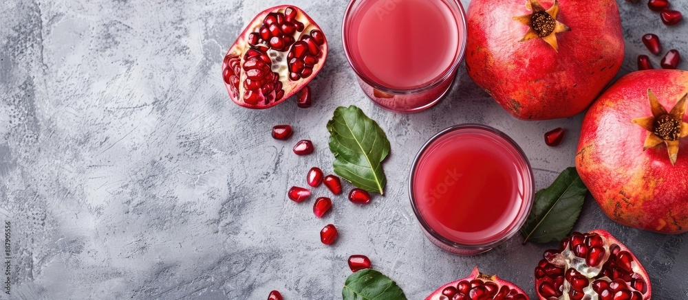 Fototapete A glass of pomegranate juice with fresh fruits on a gray concrete backdrop representing a healthy drink idea with room for text or images. with copy space image. Place for adding text or design