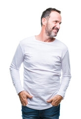 Fototapeta premium Middle age hoary senior man wearing white t-shirt over isolated background looking away to side with smile on face, natural expression. Laughing confident.