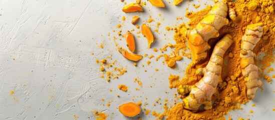 Top down view of root turmeric frame and powdered curcuma on a white concrete backdrop with room for text This healthy spice boosts immunity and acts as a natural antiseptic Ideal for copy space imag
